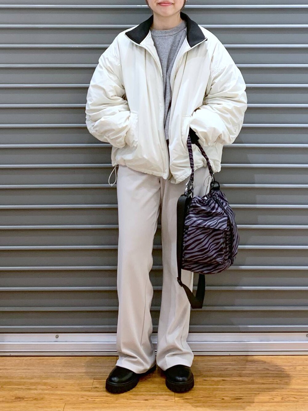 その他のショルダーバッグ、グレー系のニット/セーター、ブラック系のブーツを着用したレディースの冬コーディネートの7枚目の写真