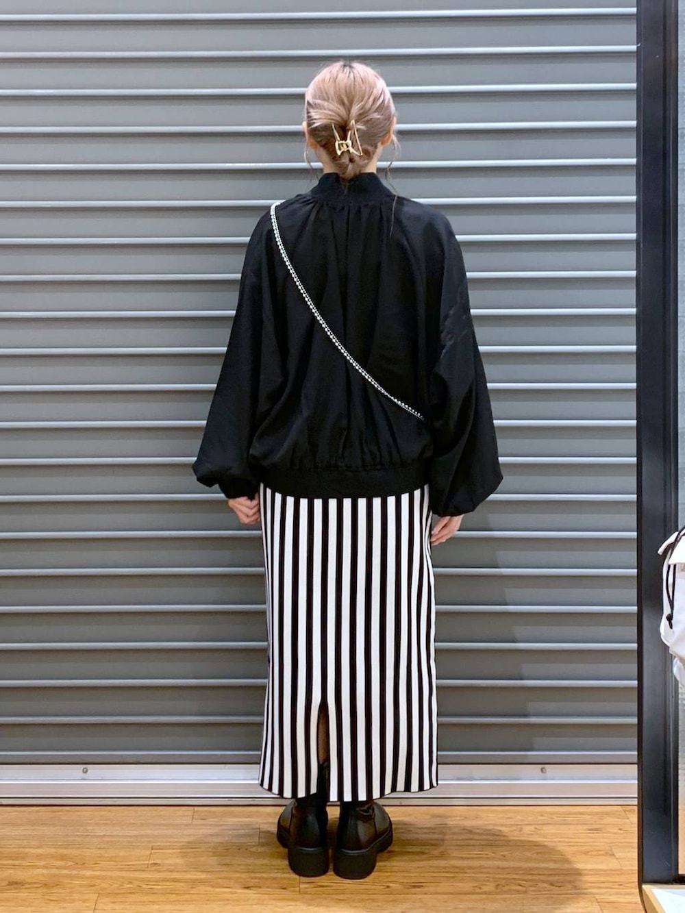 ブラック系のブルゾン、ブラック系のスカート、ブラック系のブーツを着用したレディースの秋コーディネートの2枚目の写真