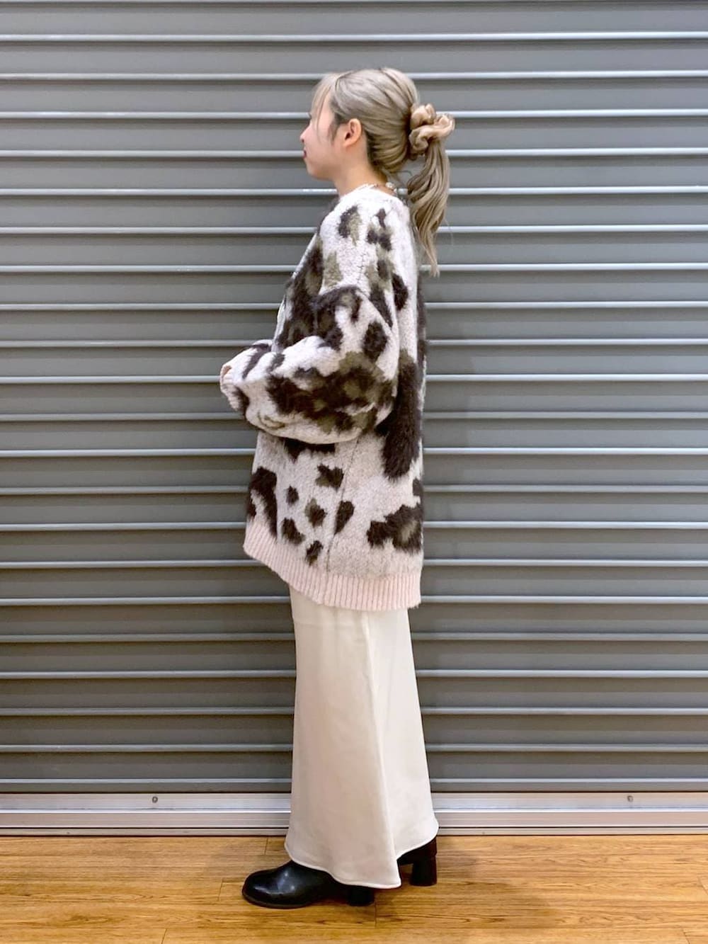 ホワイト系のスカート、ブラック系のショルダーバッグ、ブラック系のブーツを着用したレディースの冬コーディネートの3枚目の写真