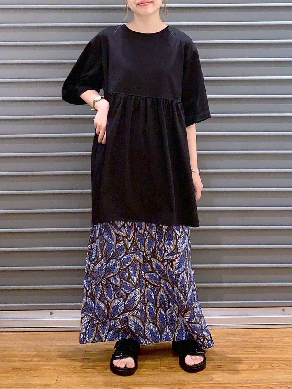 ブルー系のスカート、シルバー系のショルダーバッグ、ブラック系のサンダルを着用したレディースの夏コーディネートの5枚目の写真