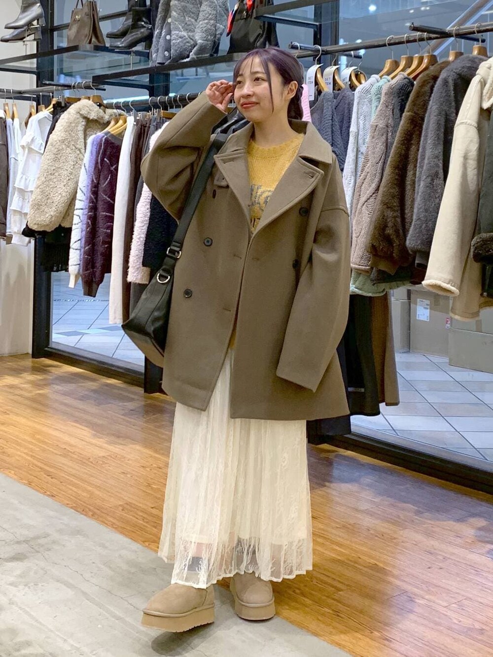 ブラウン系のその他アウター、ブラック系のショルダーバッグ、イエロー系のニット/セーターを着用したレディースの冬コーディネートの6枚目の写真