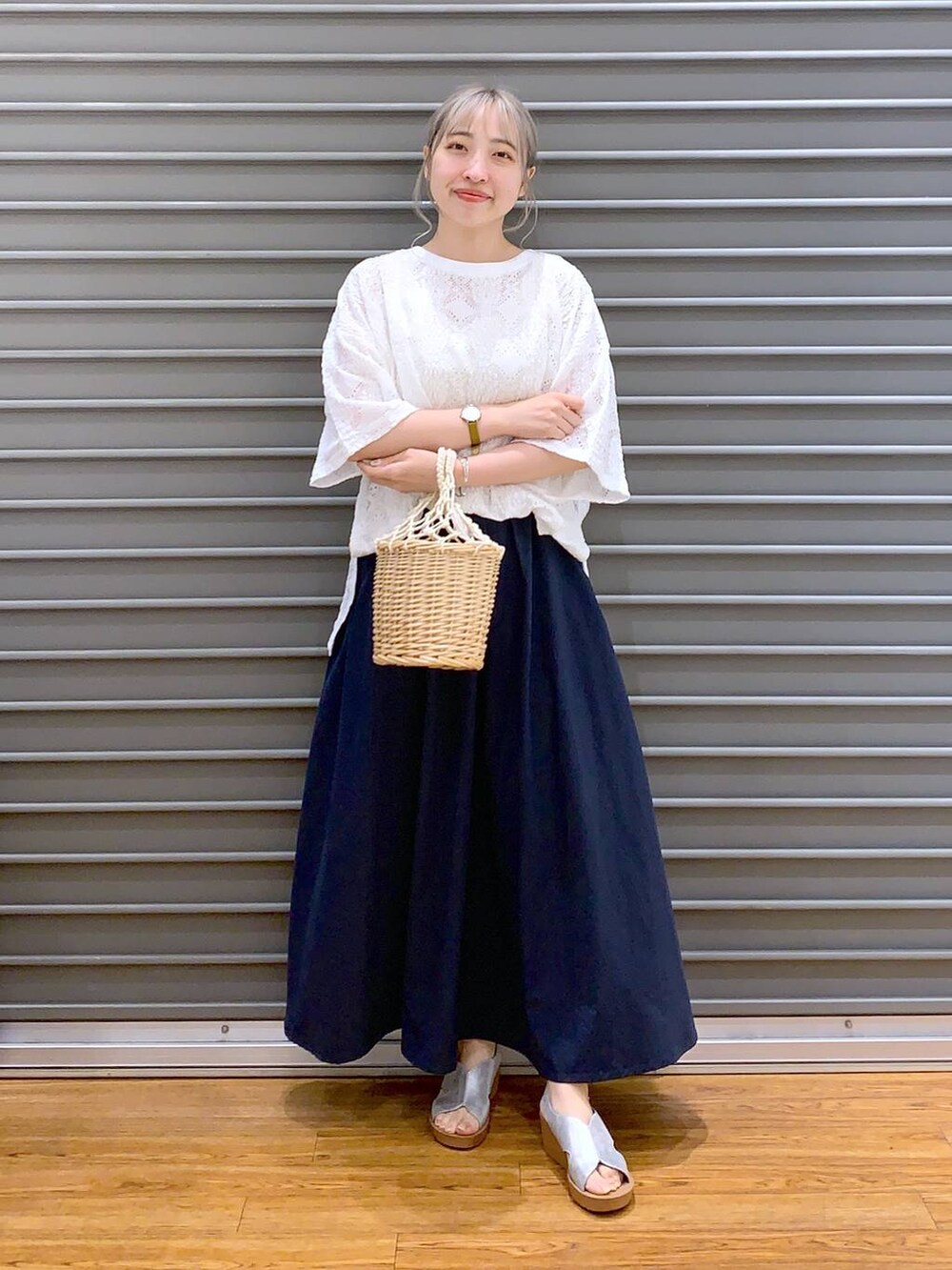ブルー系のスカート、シルバー系のサンダル、ホワイト系のかごバッグを着用したレディースの夏コーディネートの6枚目の写真