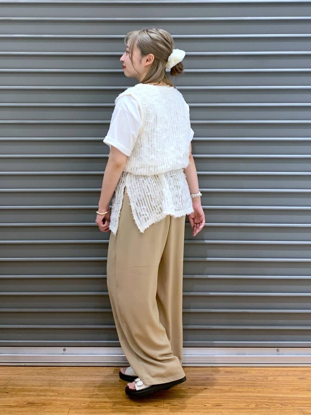 ベージュ系のその他パンツ、ホワイト系のベスト、ホワイト系のサンダルを着用したレディースの春コーディネートの6枚目の写真