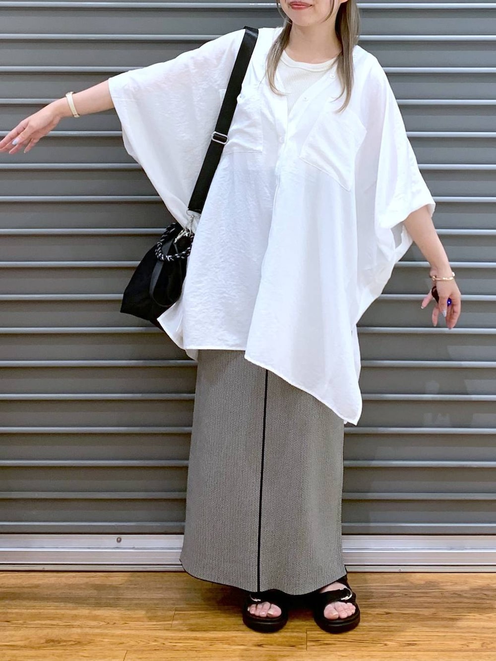 ホワイト系のTシャツ/カットソー、ブラック系のスカート、ブラック系のサンダルを着用したレディースの夏コーディネートの4枚目の写真