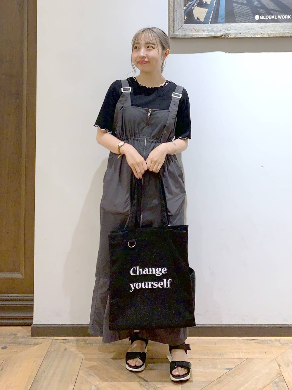 ブラック系のトートバッグ、ブラック系のサンダル、ブラック系のTシャツ/カットソーを着用したレディースの夏コーディネートの4枚目の写真