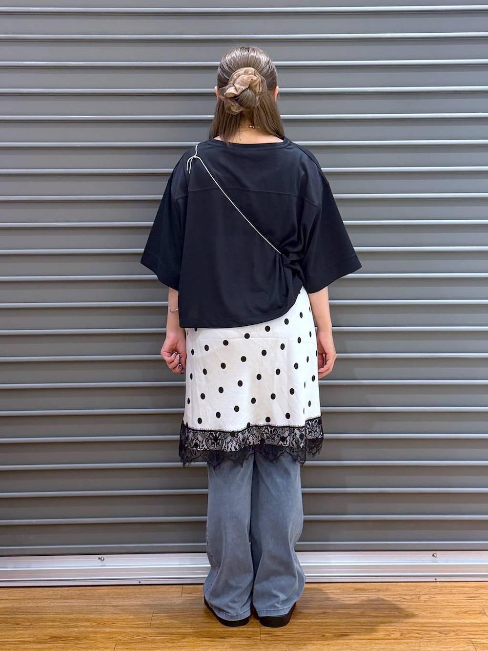 ブラック系のサンダル、ブラック系のTシャツ/カットソー、ブルー系のデニムパンツを着用したレディースの夏コーディネートの2枚目の写真