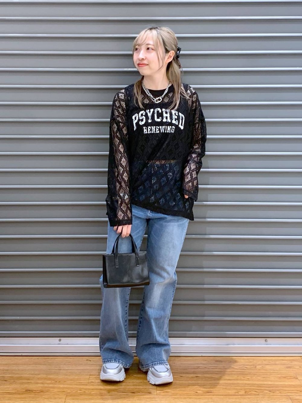 ブルー系のデニムパンツ、ブラック系のタンクトップ、シルバー系のスニーカーを着用したレディースの春コーディネートの6枚目の写真