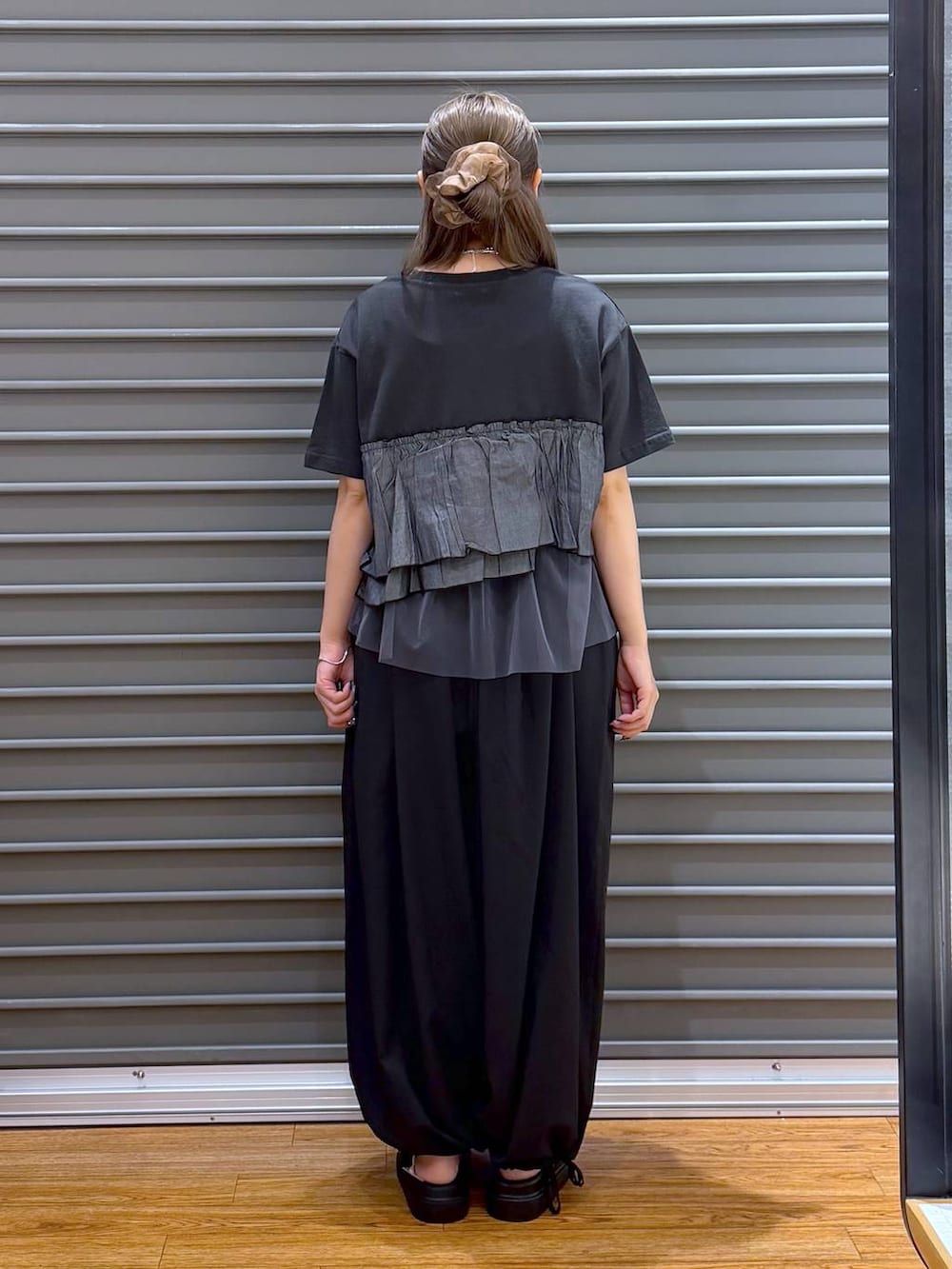 ブラック系のショルダーバッグ、ブラック系のサンダル、グレー系のTシャツ/カットソーを着用したレディースの夏コーディネートの2枚目の写真