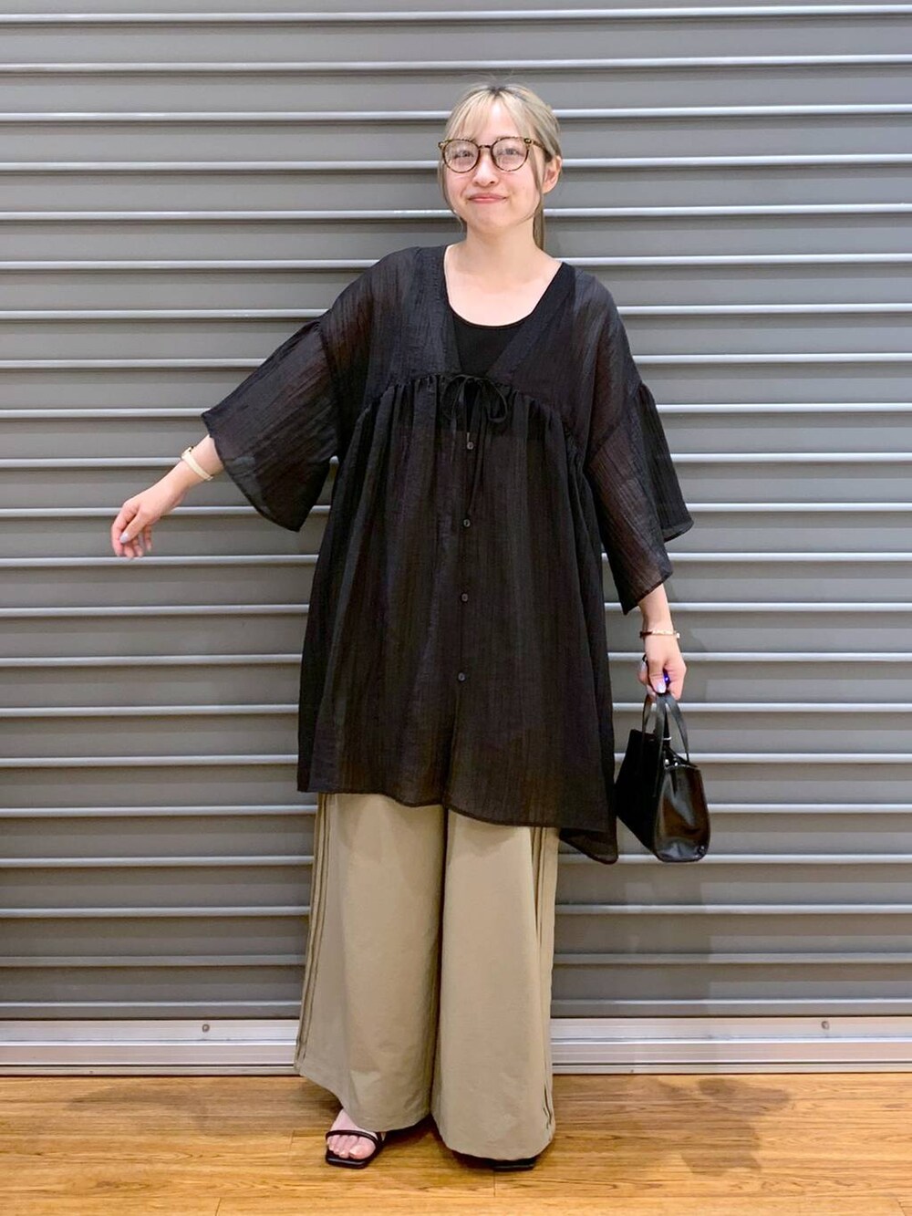 ブラック系のタンクトップ、ブラック系のショルダーバッグ、ベージュ系のその他パンツを着用したレディースの夏コーディネートの7枚目の写真