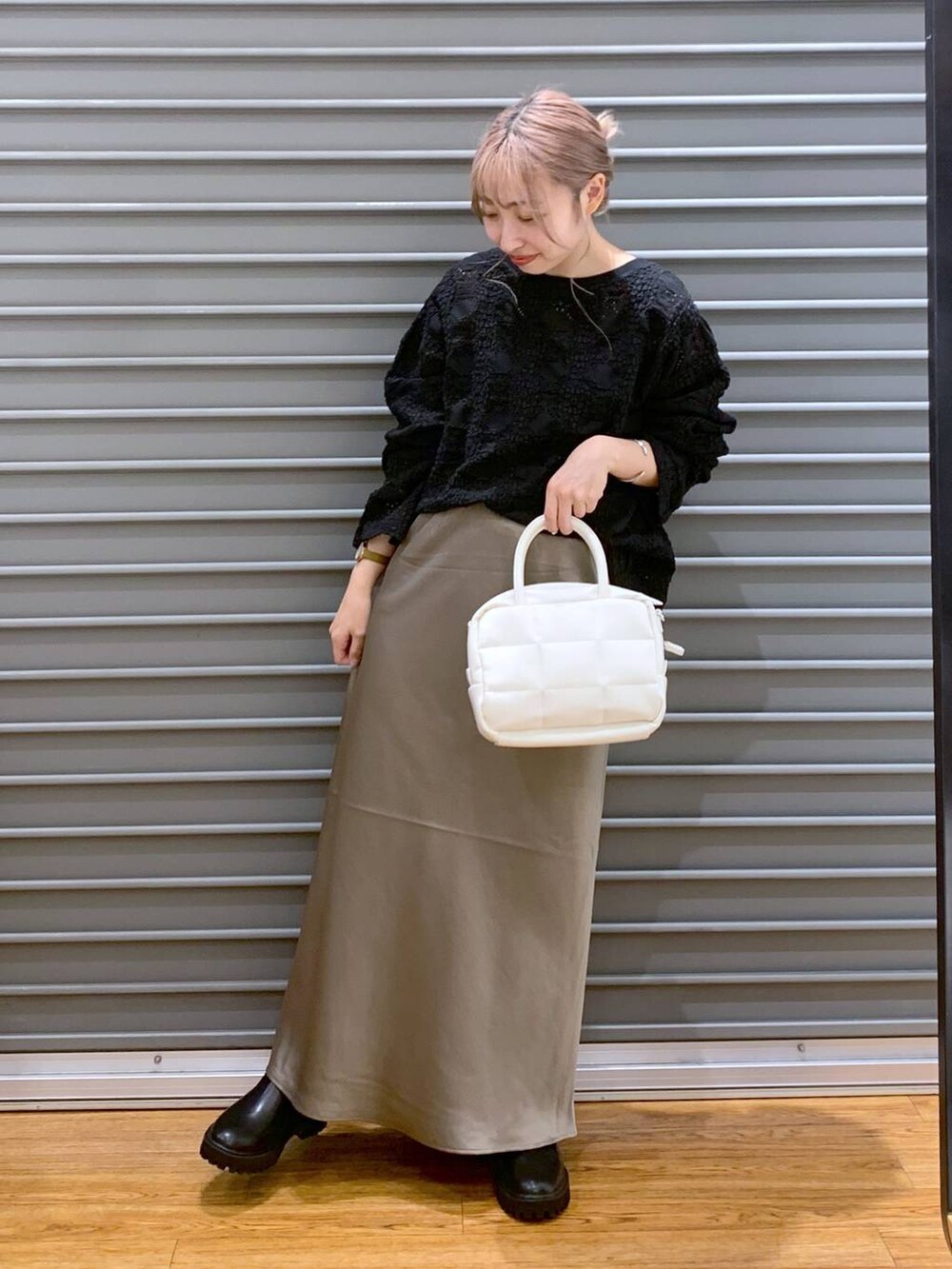 ブラック系のTシャツ/カットソー、ブラウン系のスカート、ホワイト系のボストンバッグを着用したレディースの秋コーディネートの4枚目の写真