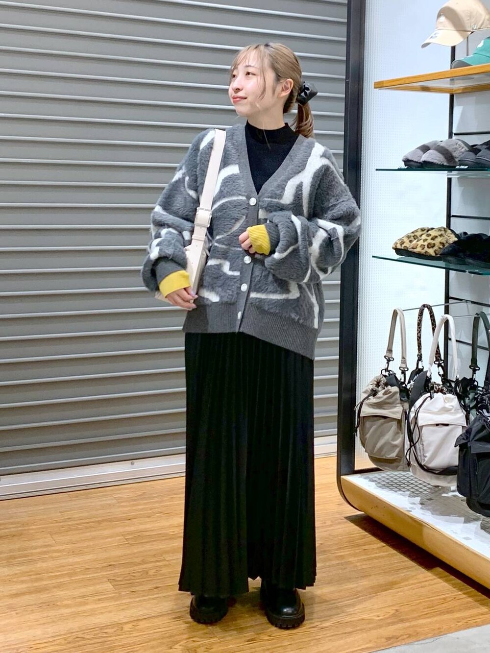 ブラック系のブーツ、ブラック系のニット/セーター、グレー系のカーディガン/ボレロを着用したレディースの冬コーディネートの4枚目の写真