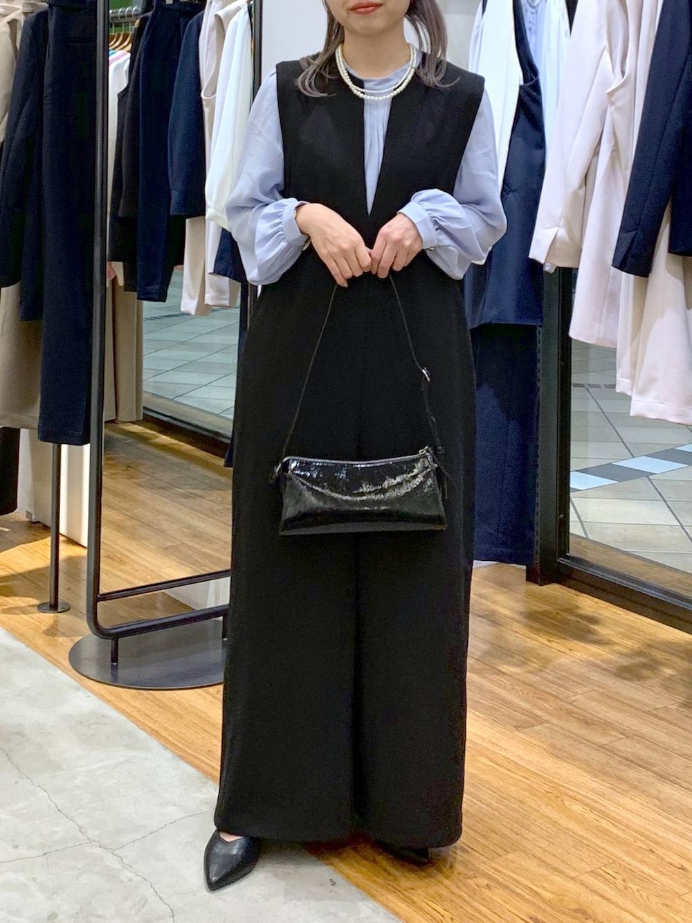 ブルー系のシャツ/ブラウス、ブラック系のサロペット/オーバーオール、ブラック系のパンプスを着用したレディースの冬コーディネートの6枚目の写真