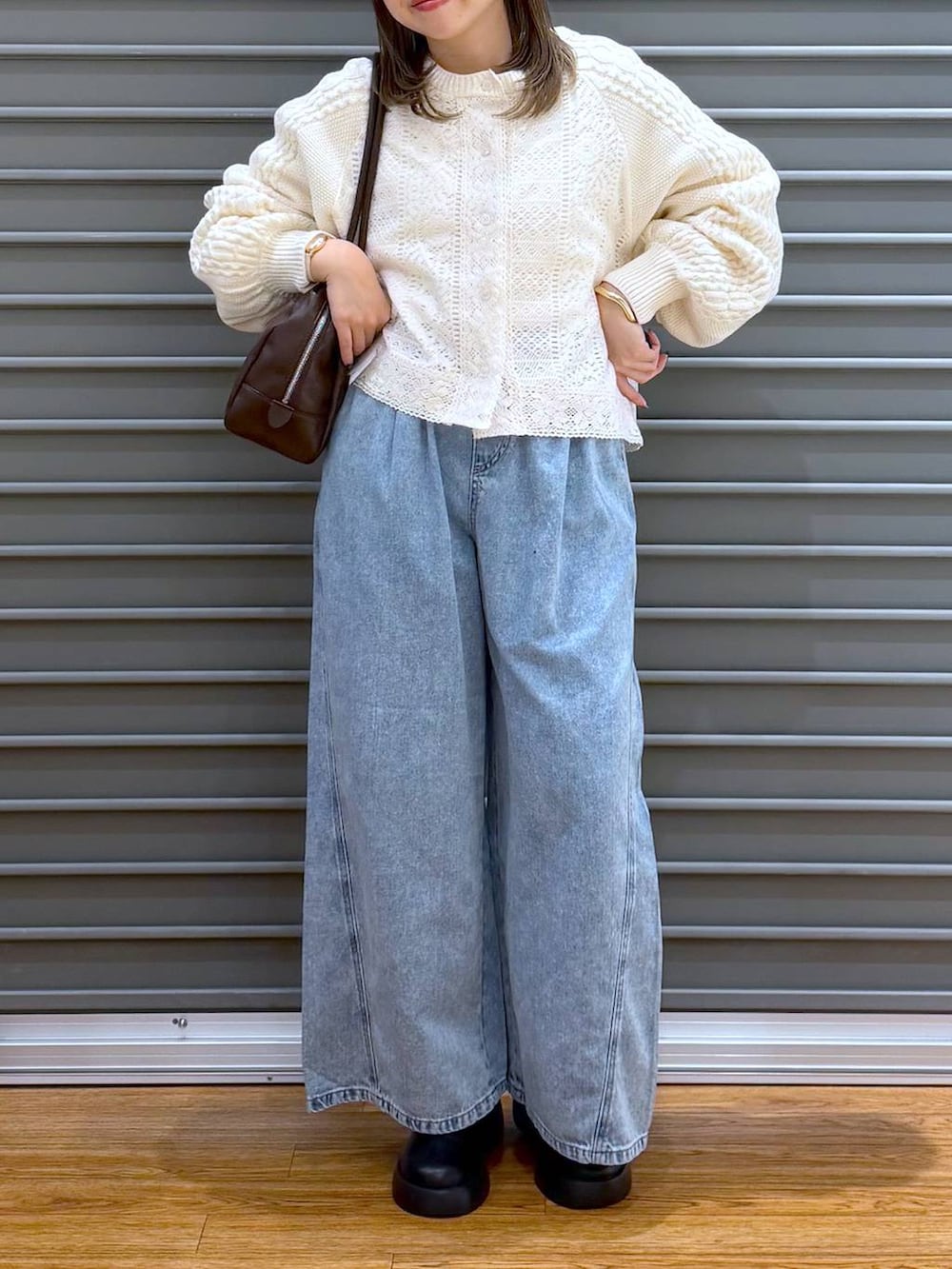 ブラック系のサンダル、ブルー系のデニムパンツ、ブラウン系のボストンバッグを着用したレディースの春コーディネートの7枚目の写真