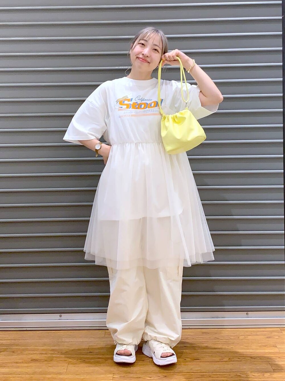 ホワイト系のサンダル、イエロー系のショルダーバッグ、ホワイト系のカーゴパンツを着用したレディースの春コーディネートの5枚目の写真