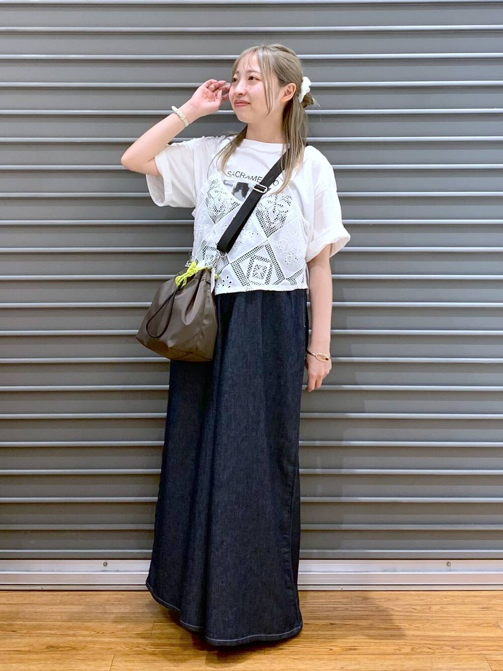 ブラック系のサンダル、ブルー系のデニムパンツ、ブラウン系のショルダーバッグを着用したレディースの夏コーディネートの4枚目の写真