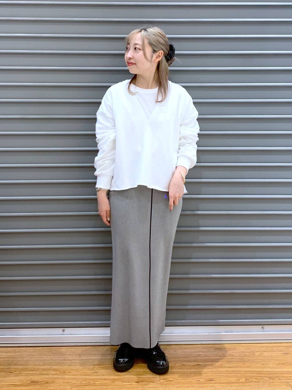 ピンク系のショルダーバッグ、ブラック系のローファー、ブラック系のスカートを着用したレディースの春コーディネートの3枚目の写真