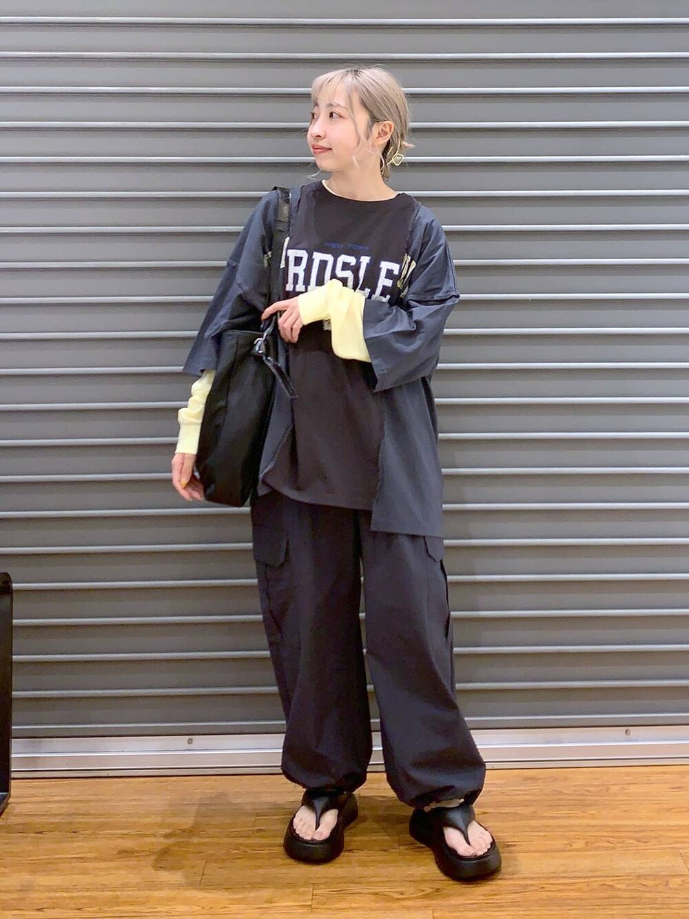 ブラック系のサンダル、グレー系のカーゴパンツ、イエロー系のTシャツ/カットソーを着用したレディースの春コーディネートの3枚目の写真