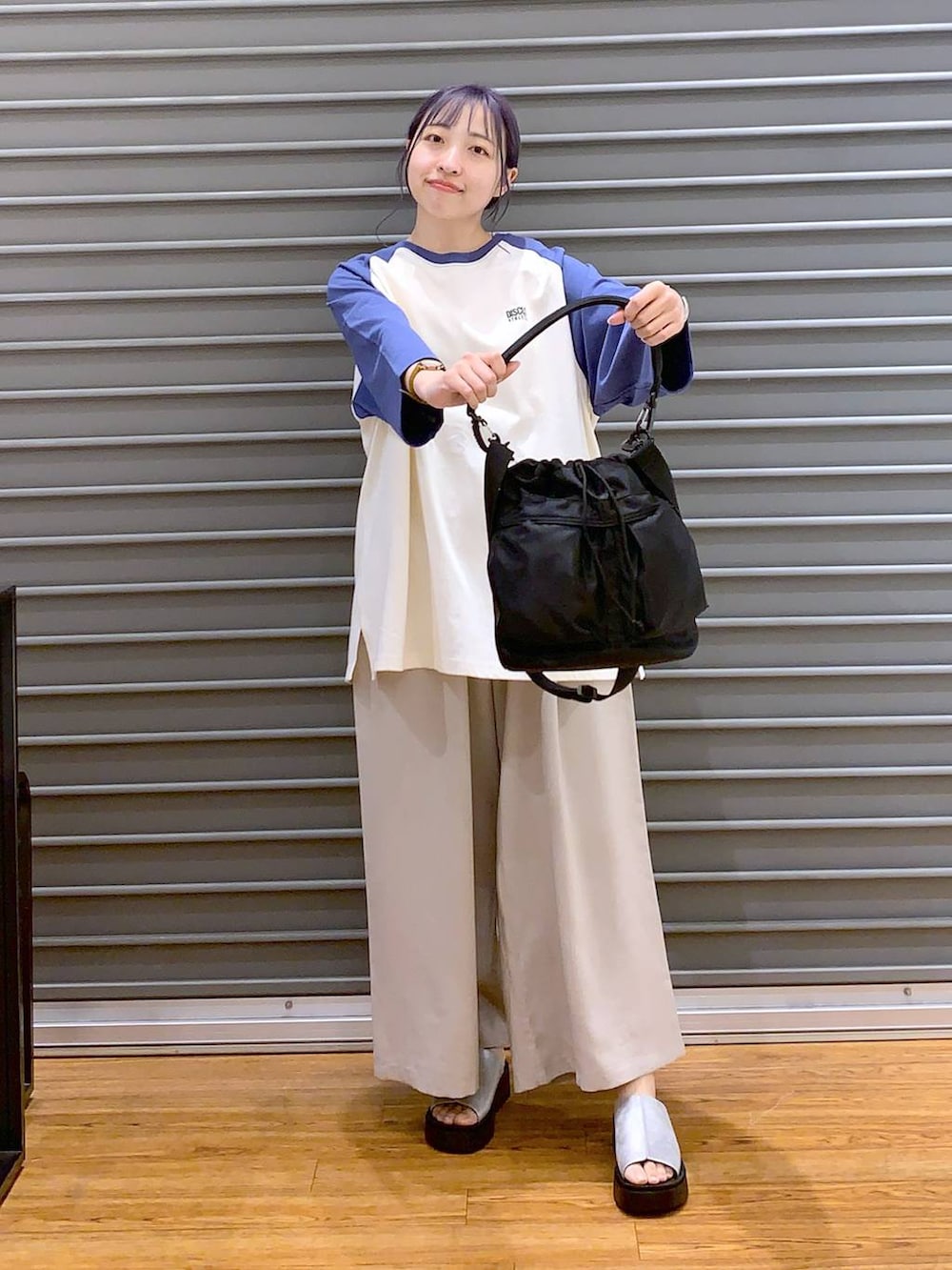 ブルー系のTシャツ/カットソー、ベージュ系のその他パンツ、ブラック系のショルダーバッグを着用したレディースの春コーディネートの6枚目の写真