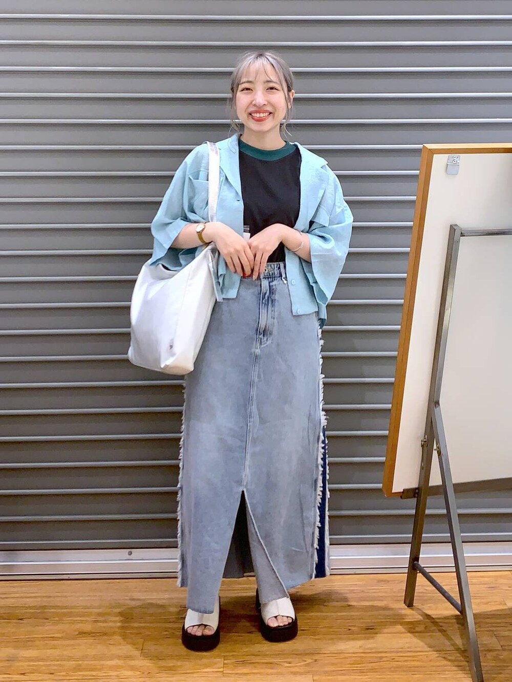 グレー系のタンクトップ、グレー系のショルダーバッグ、ホワイト系のサンダルを着用したレディースの夏コーディネートの4枚目の写真