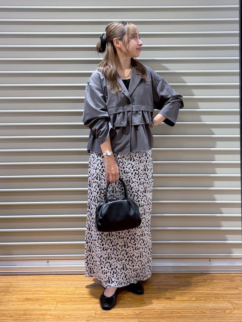 ブラック系のショルダーバッグ、グレー系のテーラードジャケット、ホワイト系のスカートを着用したレディースの秋コーディネートの4枚目の写真