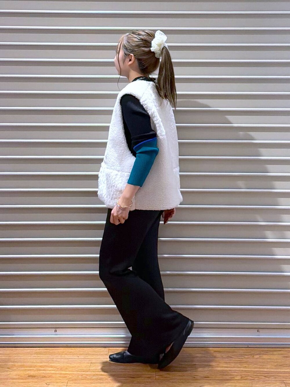 ブラック系のショルダーバッグ、ブラック系のその他パンツ、ホワイト系のベストを着用したレディースの秋コーディネートの3枚目の写真