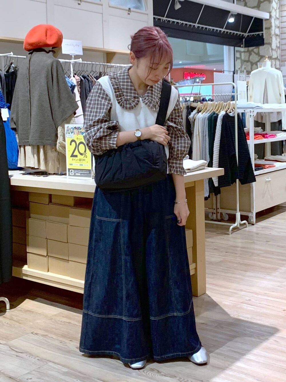 ホワイト系のベスト、ブルー系のデニムパンツ、その他のパンプスを着用したレディースの秋コーディネートの4枚目の写真