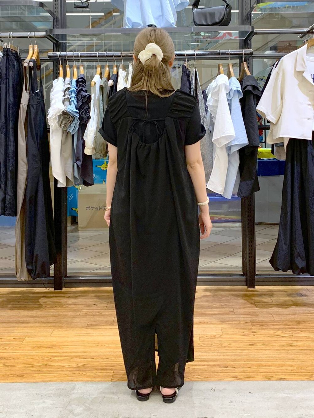 ホワイト系のサンダル、ホワイト系のショルダーバッグ、ブラック系のジャンパースカートを着用したレディースの夏コーディネートの2枚目の写真