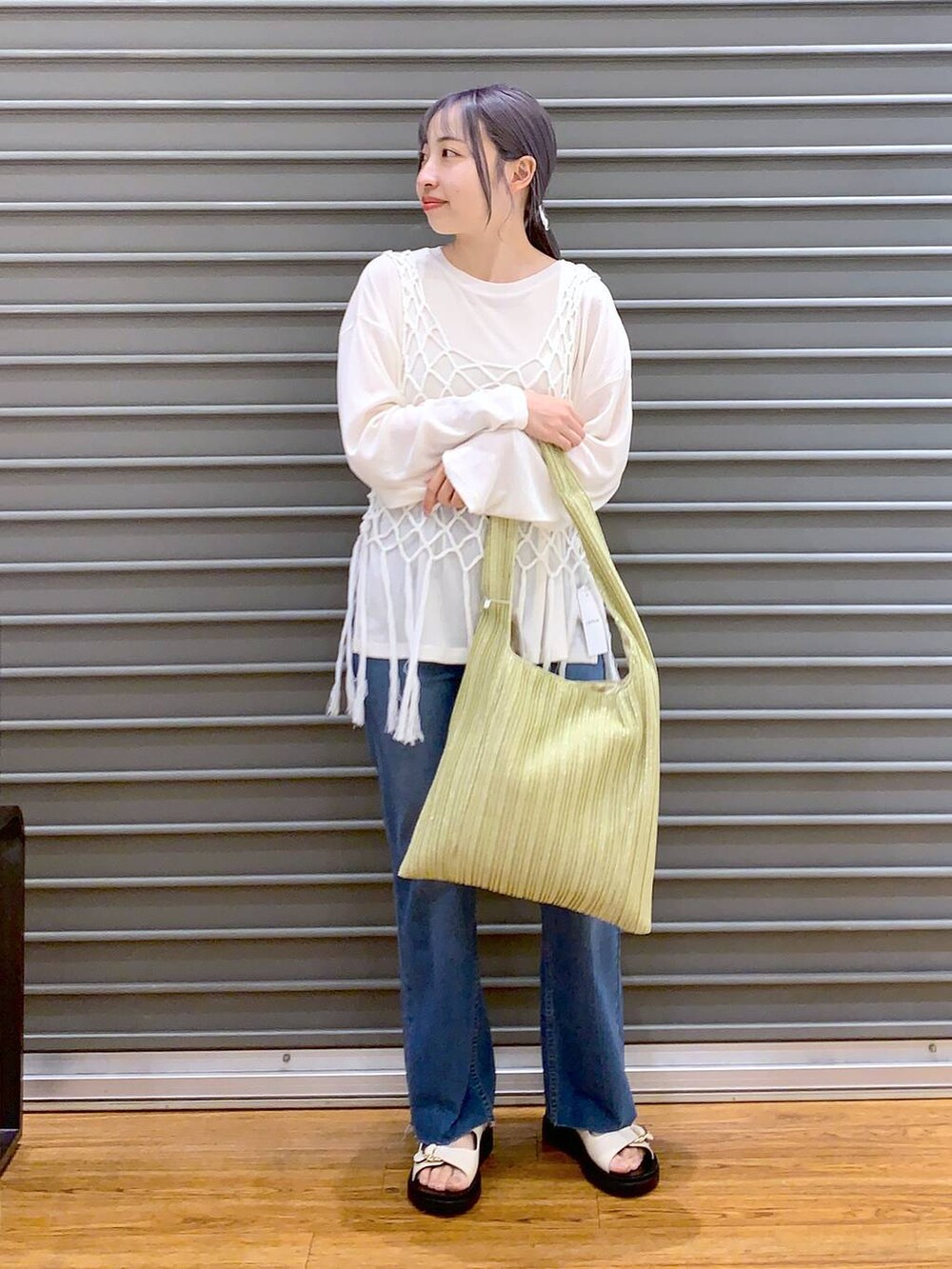 ホワイト系のTシャツ/カットソー、ホワイト系のベスト、ブルー系のデニムパンツを着用したレディースの春コーディネートの3枚目の写真