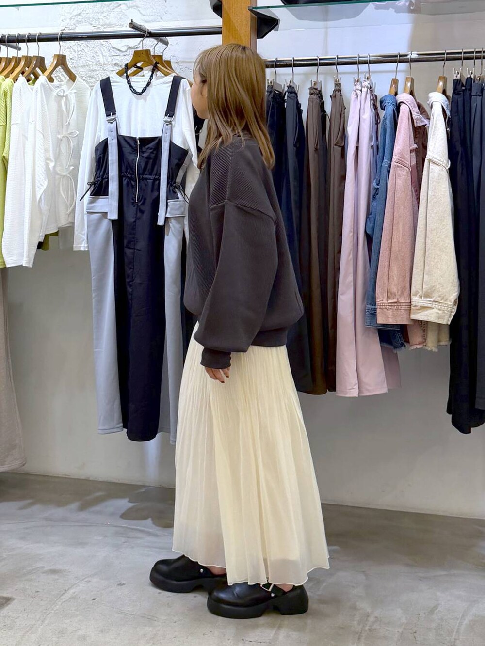 ブラック系のサンダル、ブラック系のボストンバッグ、ホワイト系のスカートを着用したレディースの春コーディネートの3枚目の写真