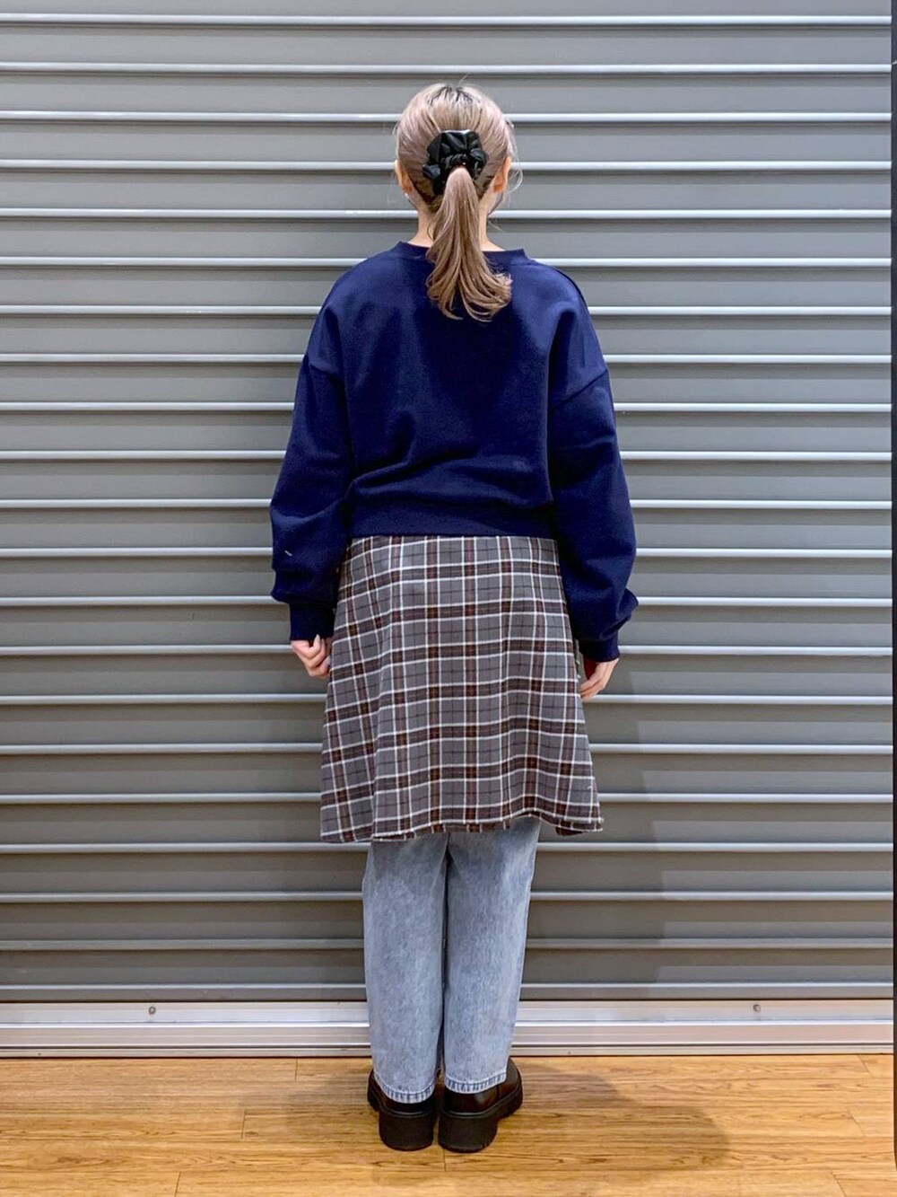 ブラック系のショルダーバッグ、ブルー系のデニムパンツ、ブラック系のブーツを着用したレディースの冬コーディネートの3枚目の写真