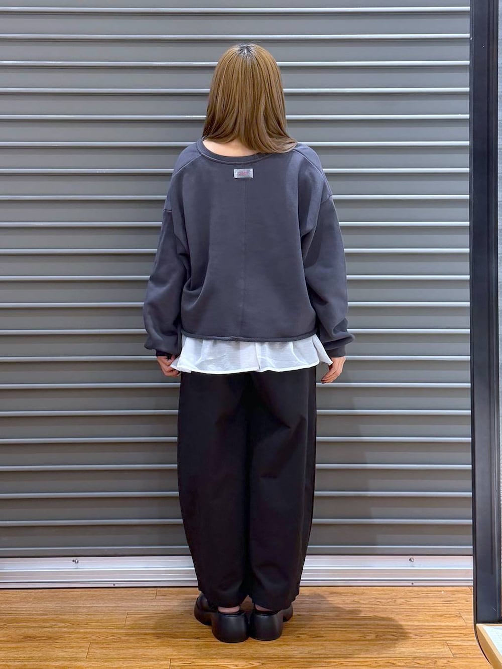 ブラック系のサンダル、ブラック系のショルダーバッグ、ホワイト系のキャミソールを着用したレディースの春コーディネートの2枚目の写真