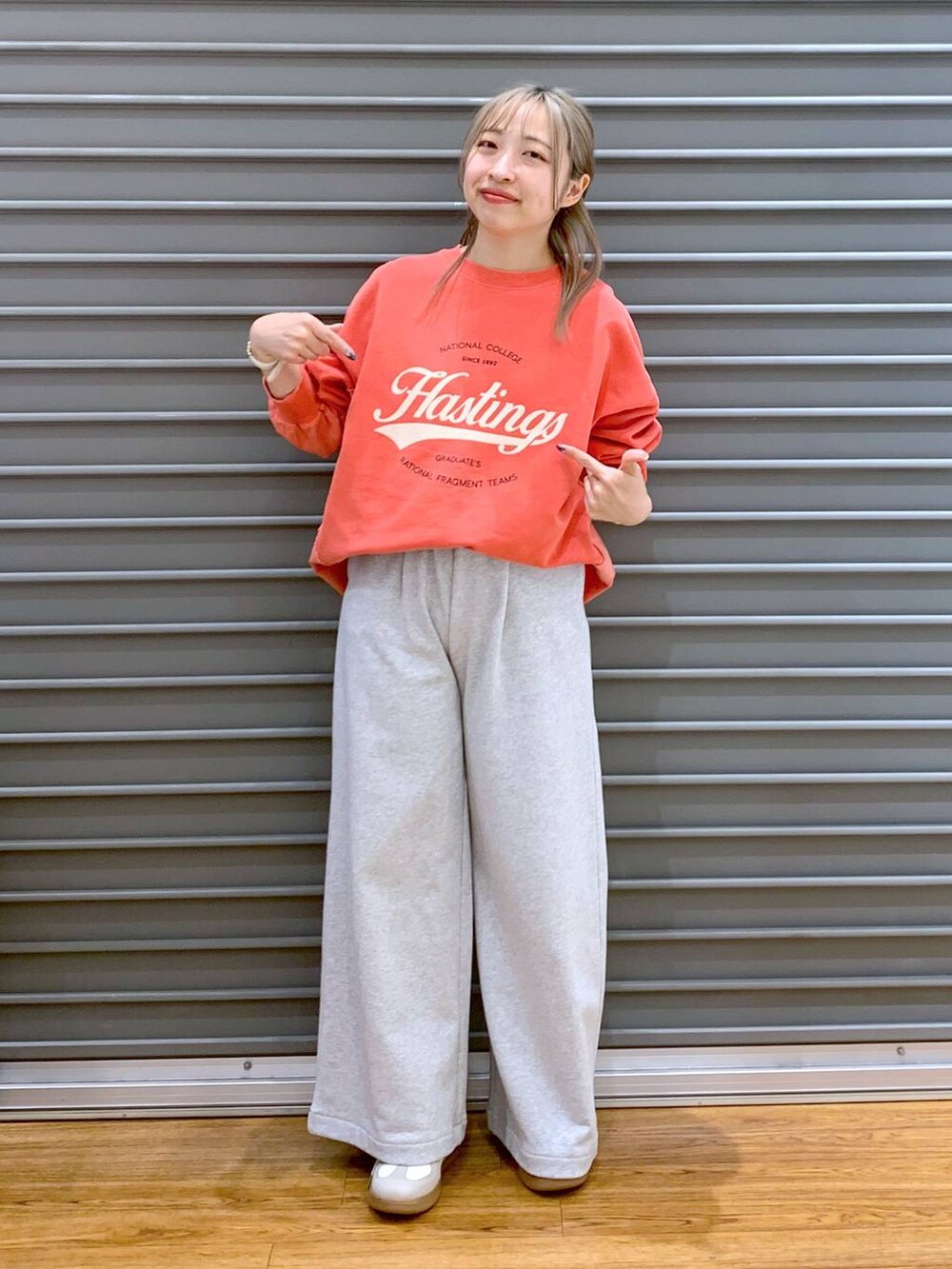 ホワイト系のスニーカー、ブラック系のショルダーバッグ、レッド系のスウェットを着用したレディースの冬コーディネートの6枚目の写真