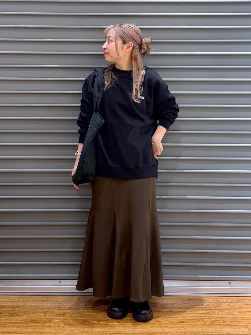 ブラック系のサンダル、ブラウン系のスカート、ブラック系のスウェットを着用したレディースの冬コーディネートの7枚目の写真