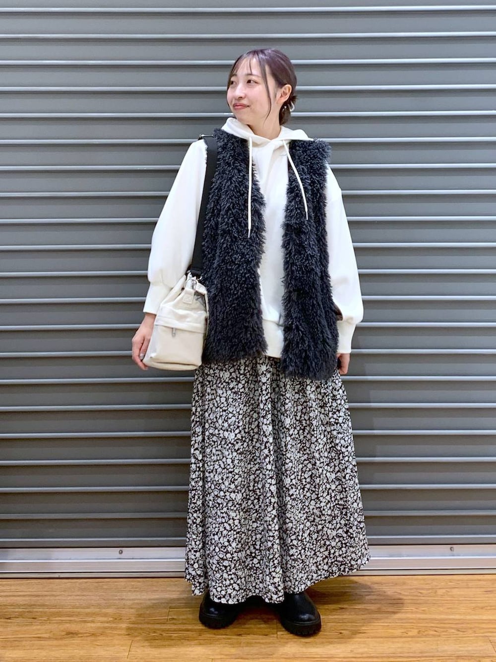 ブラック系のブーツ、ホワイト系のショルダーバッグ、ホワイト系のパーカーを着用したレディースの秋コーディネートの4枚目の写真