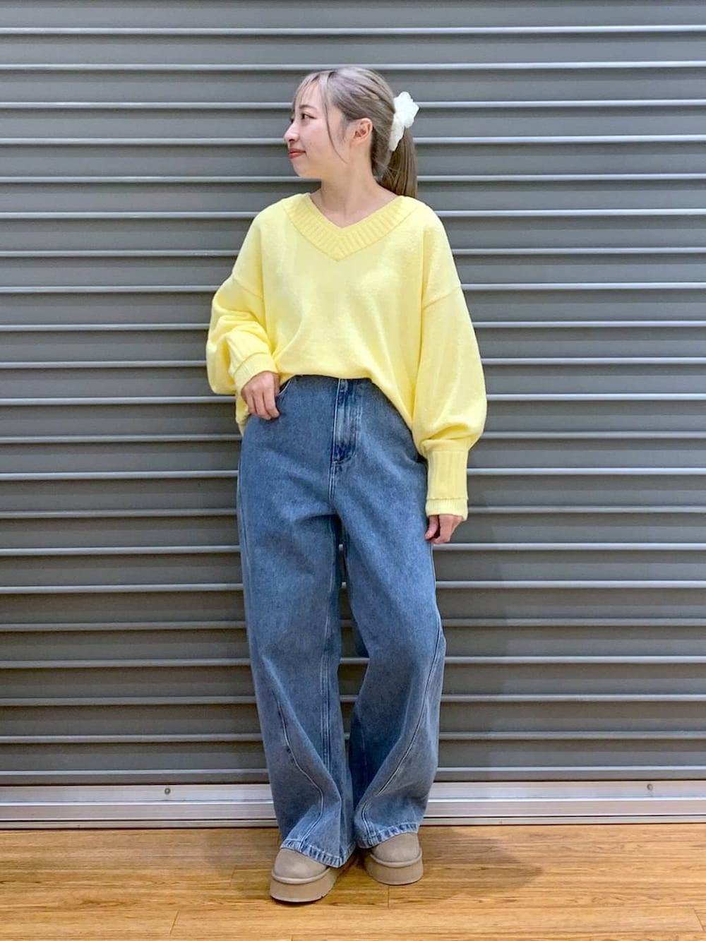 イエロー系のニット/セーター、ブラック系のブルゾン、ブラック系のトートバッグを着用したレディースの冬コーディネートの6枚目の写真