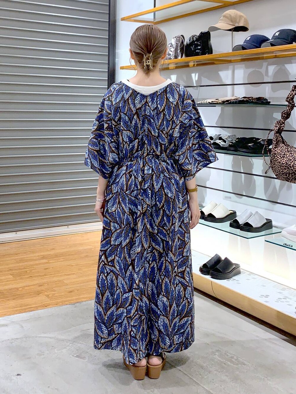 ブラック系のショルダーバッグ、ブラック系のサンダル、ホワイト系のタンクトップを着用したレディースの夏コーディネートの2枚目の写真