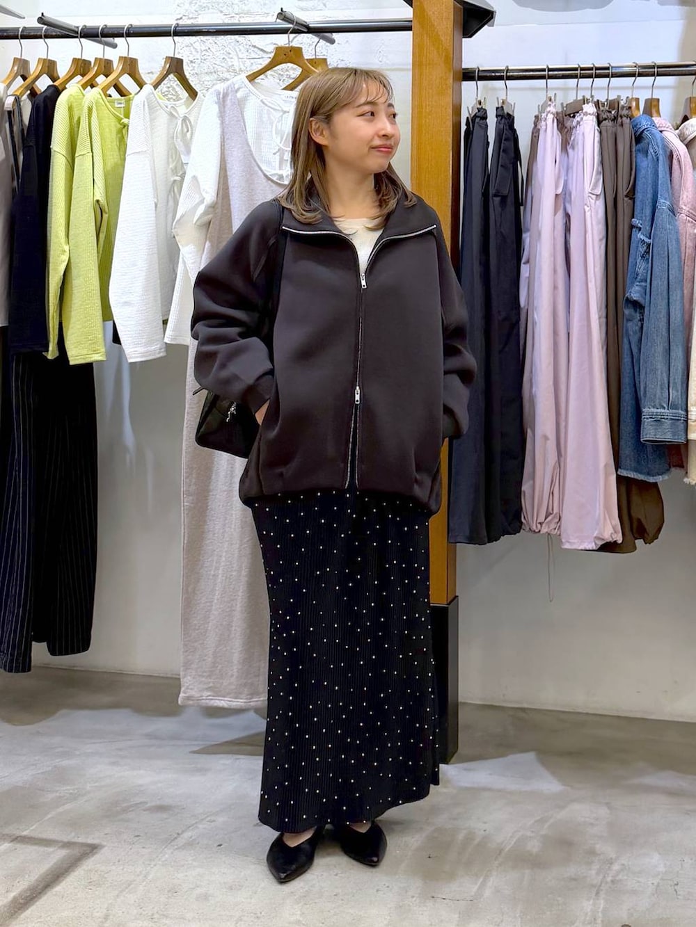 ブラック系のボストンバッグ、ブラック系のパンプス、グレー系のカーディガン/ボレロを着用したレディースの春コーディネートの4枚目の写真