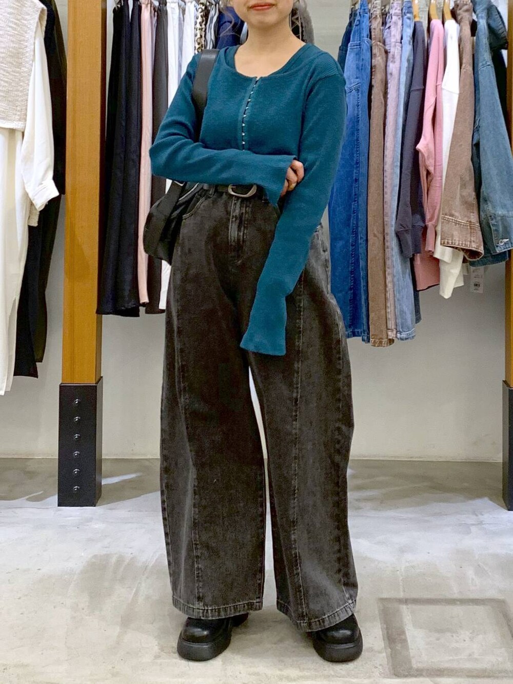 グリーン系のTシャツ/カットソー、ブラック系のデニムパンツ、ブラック系のショルダーバッグを着用したレディースの春コーディネートの6枚目の写真