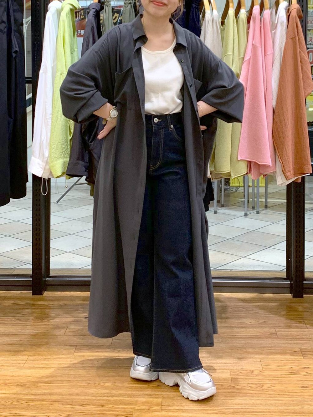 グレー系のワンピース、ホワイト系のタンクトップ、ブルー系のデニムパンツを着用したレディースの春コーディネートの5枚目の写真