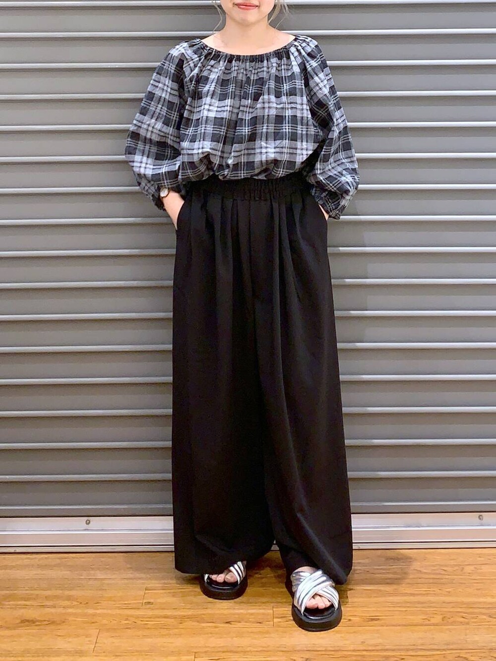 ブラック系のショルダーバッグ、シルバー系のサンダル、ブラック系のスラックスを着用したレディースの夏コーディネートの4枚目の写真