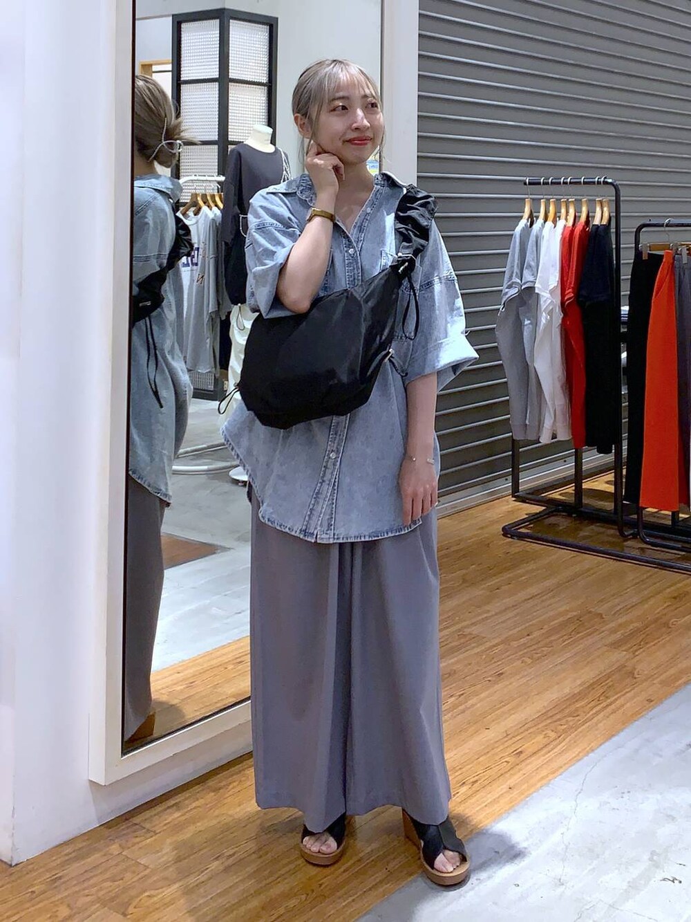 ブルー系のシャツ/ブラウス、ブラック系のサンダル、グレー系のスラックスを着用したレディースの夏コーディネートの2枚目の写真