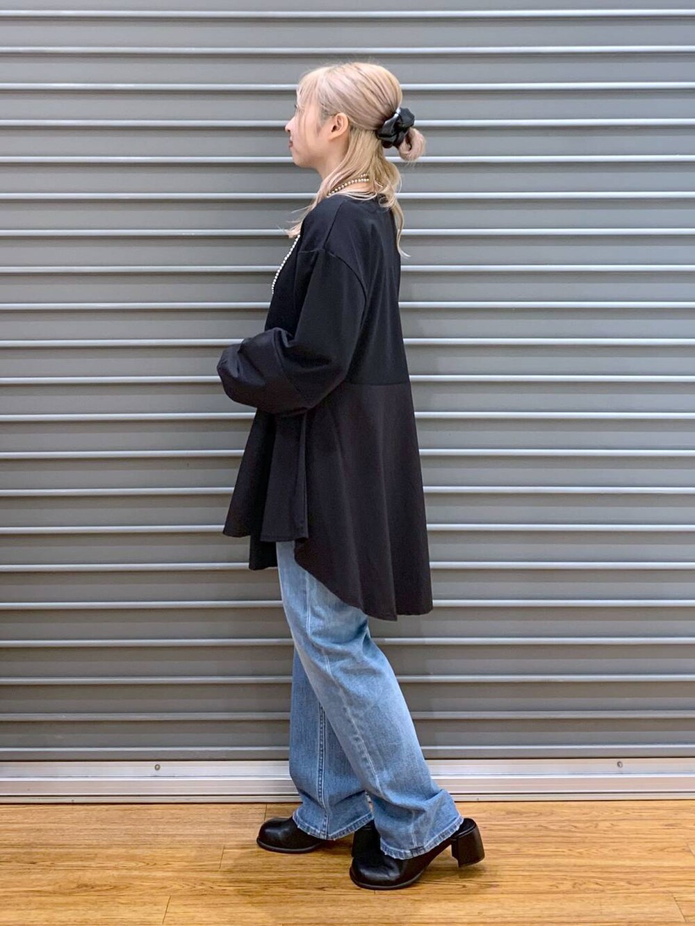 ブルー系のデニムパンツ、グレー系のショルダーバッグ、ブラック系のその他シューズを着用したレディースの秋コーディネートの3枚目の写真