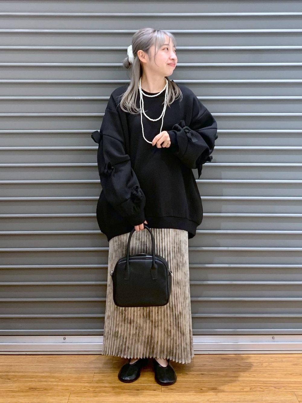 ホワイト系のスカート、ブラック系のボストンバッグ、ブラック系のスウェットを着用したレディースの秋コーディネートの4枚目の写真