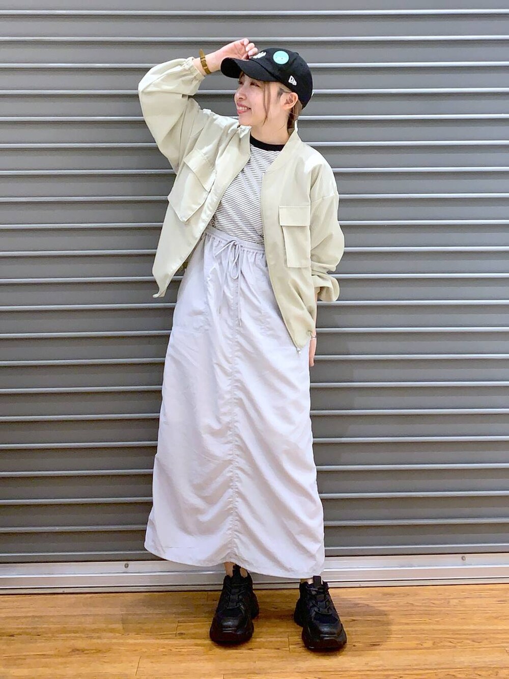 ブラック系のスニーカー、グレー系のTシャツ/カットソー、グレー系のスカートを着用したレディースの春コーディネートの5枚目の写真