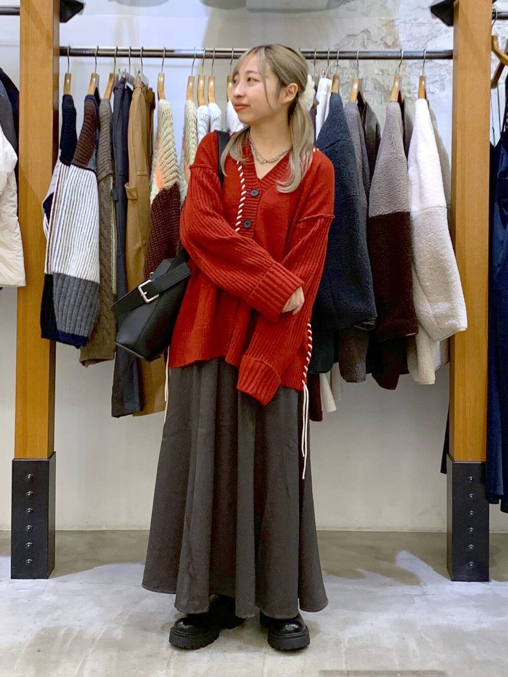 ブラック系のブーツ、ブラック系のショルダーバッグ、レッド系のカーディガン/ボレロを着用したレディースの冬コーディネートの4枚目の写真