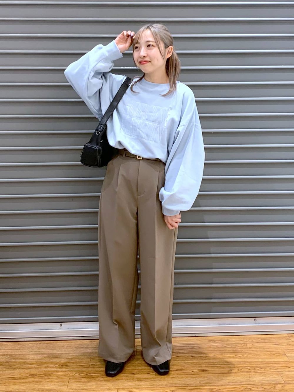 ブラック系のブーツ、ブラウン系のスーツパンツ、ブラック系のショルダーバッグを着用したレディースの冬コーディネートの3枚目の写真