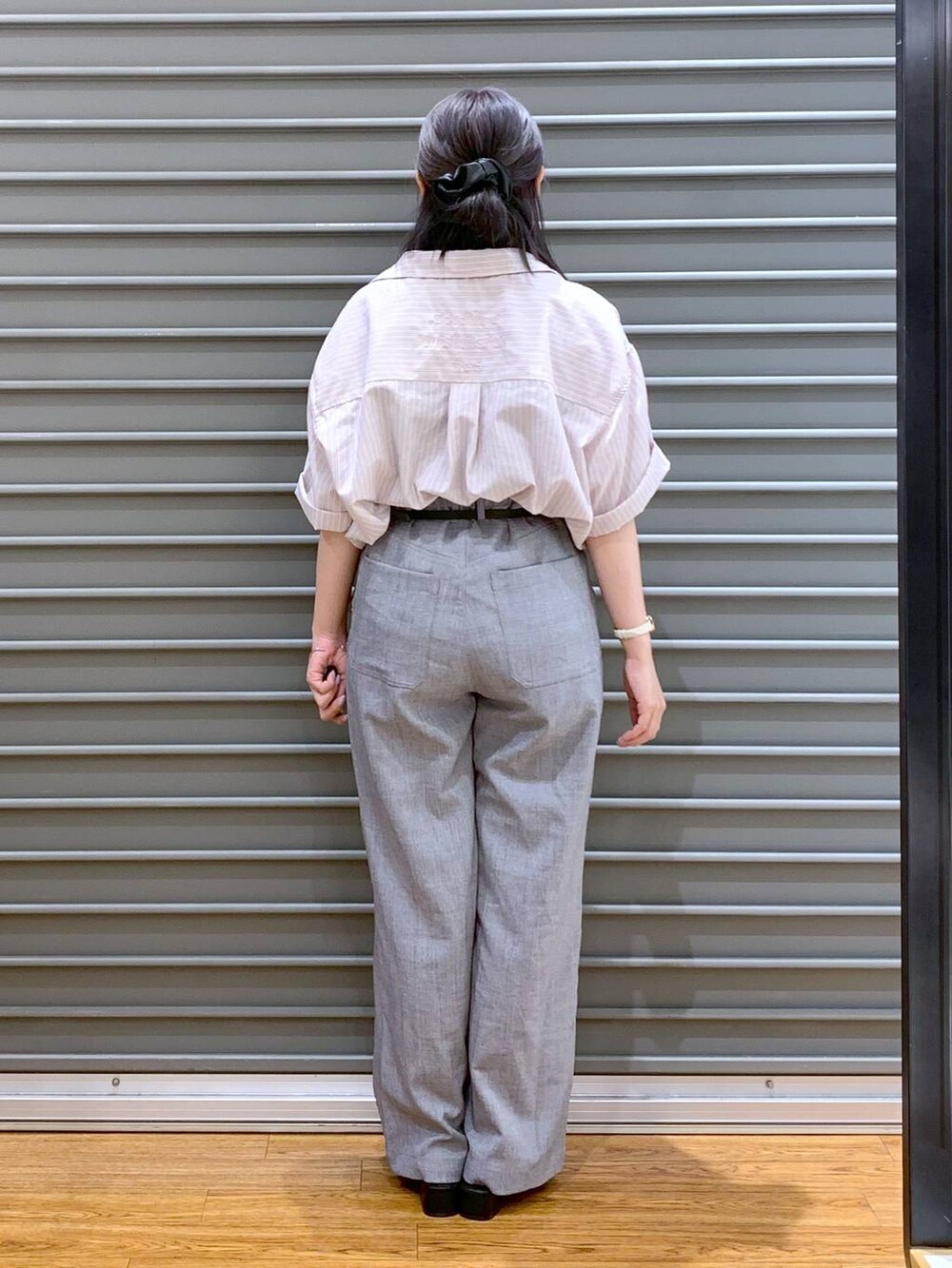 ピンク系のシャツ/ブラウス、グレー系のその他パンツ、ブラック系のショルダーバッグを着用したレディースの夏コーディネートの2枚目の写真