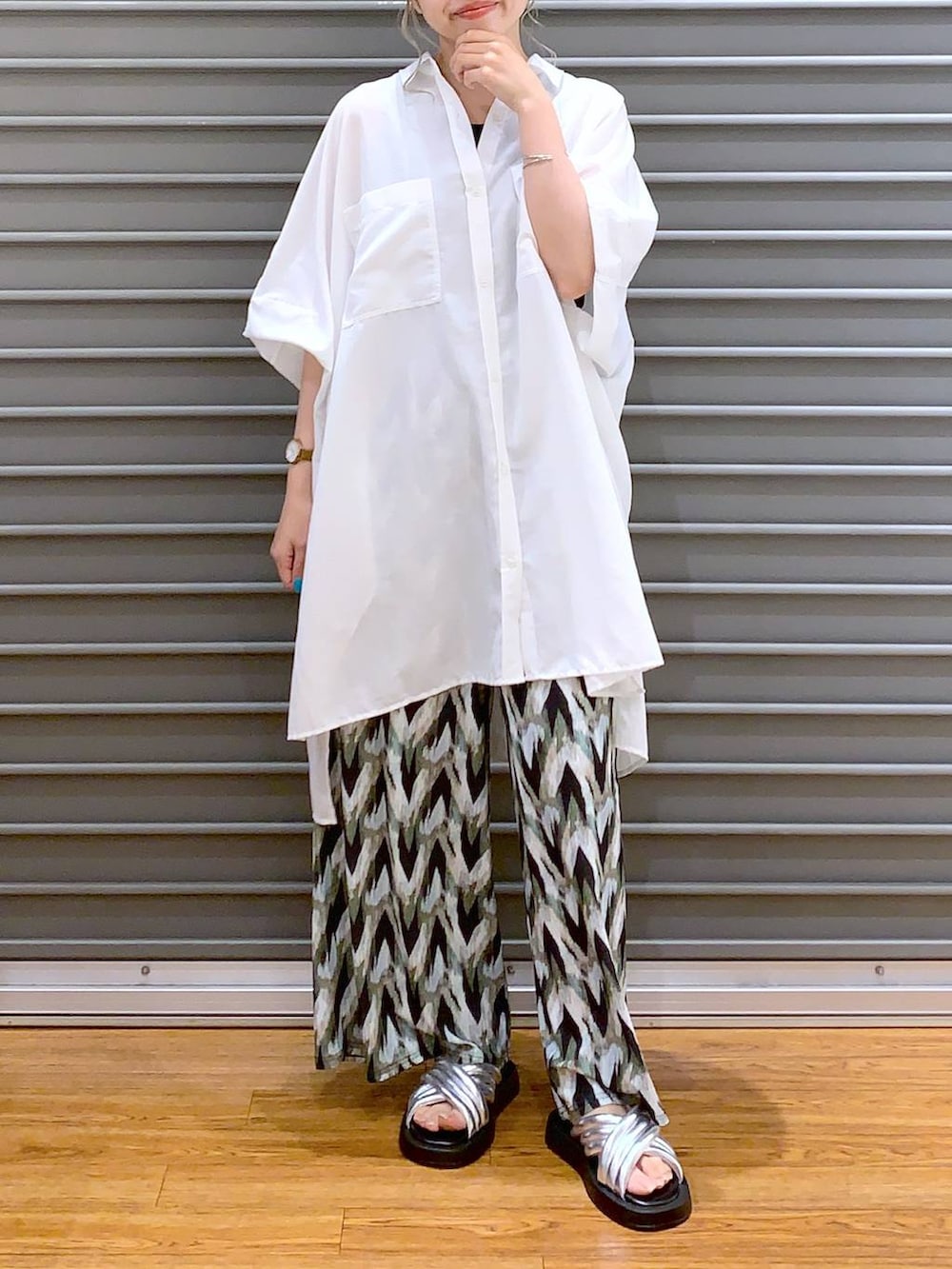 シルバー系のサンダル、ベージュ系のショルダーバッグ、ホワイト系のチュニックを着用したレディースの夏コーディネートの5枚目の写真