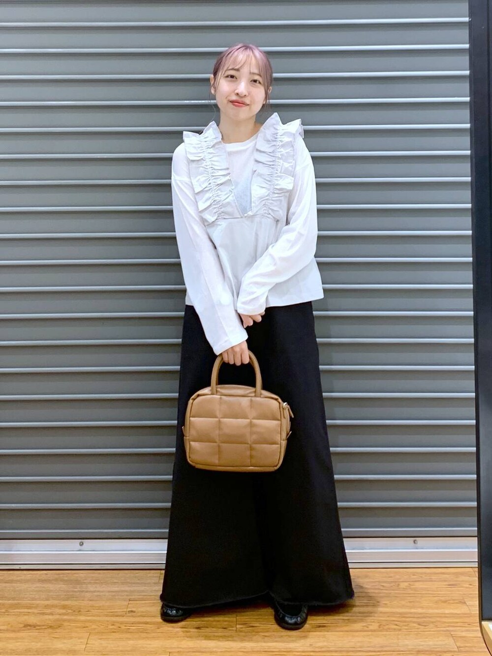 ホワイト系のTシャツ/カットソー、グレー系のスカート、ブラウン系のボストンバッグを着用したレディースの秋コーディネートの6枚目の写真