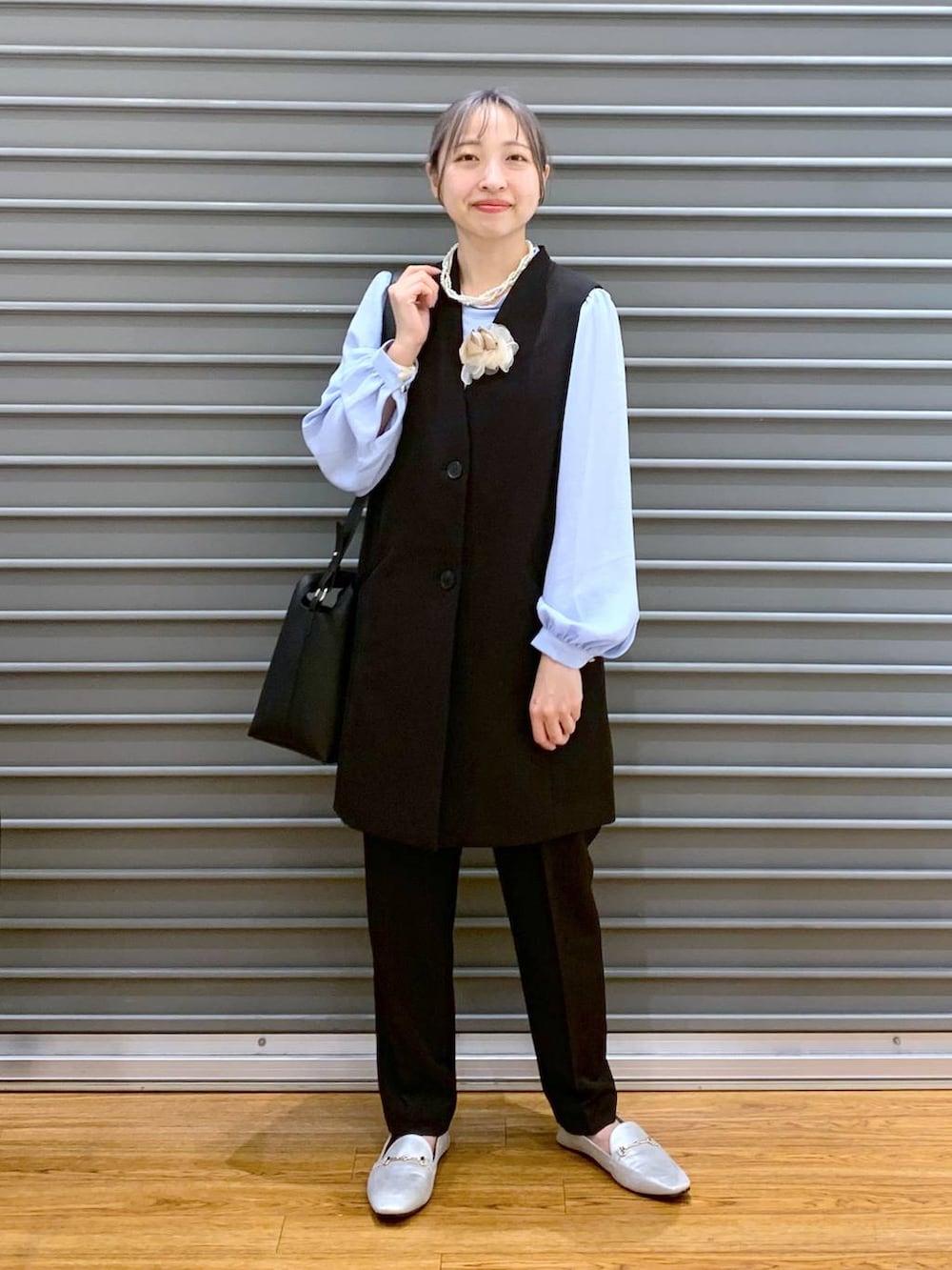 ブラック系のスーツパンツ、ブルー系のシャツ/ブラウス、ブラック系のスーツベストを着用したレディースの冬コーディネートの7枚目の写真